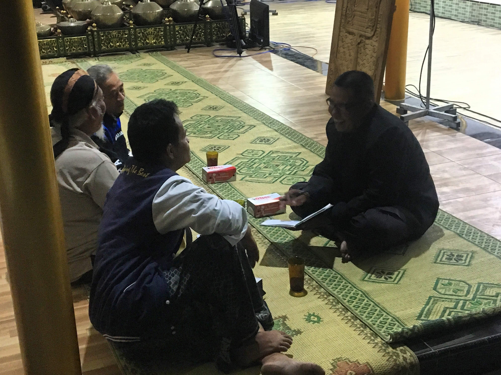 Warga komunitas budaya di Klaten berdiskusi di samping panggung gamelan — partisipasi kooperatif menjadi fondasi pengelolaan media komunitas.